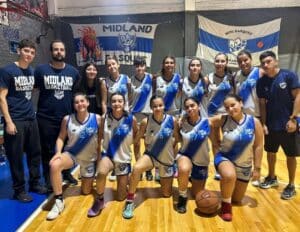 Fotografía grupal de un equipo femenino de básquetbol posando en una cancha