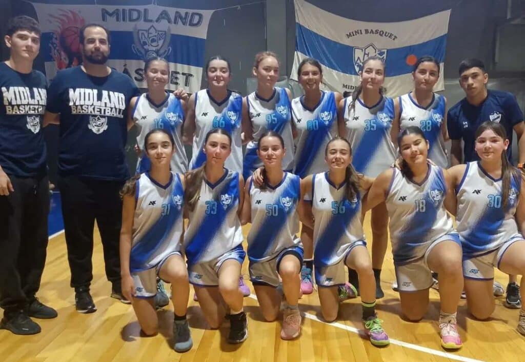 Fotografía grupal de un equipo femenino de básquetbol posando en una cancha